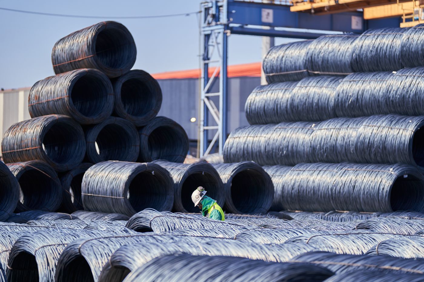 Worker among wire rod coils in the yard